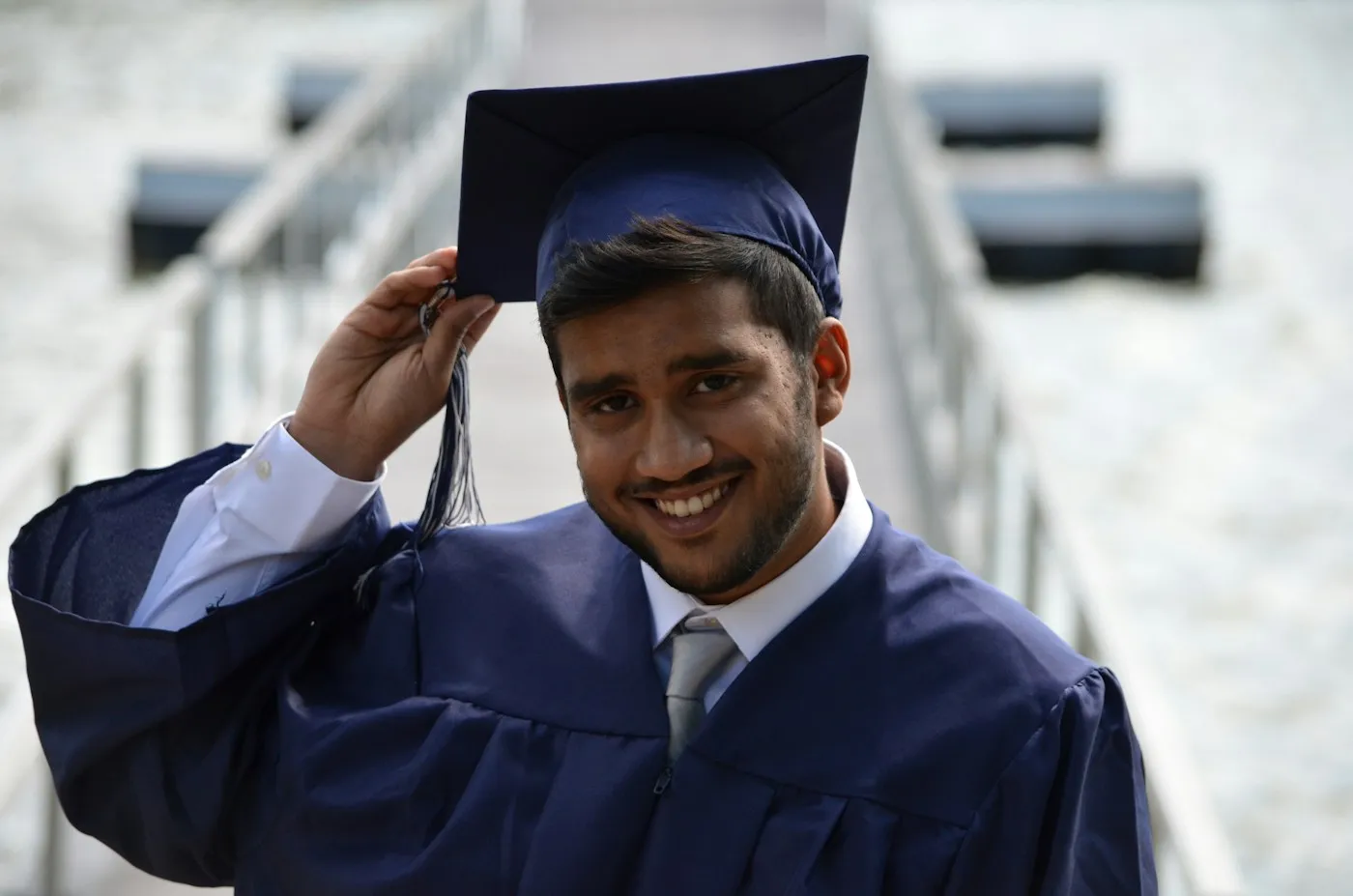 Graduate in cap and gown smiling