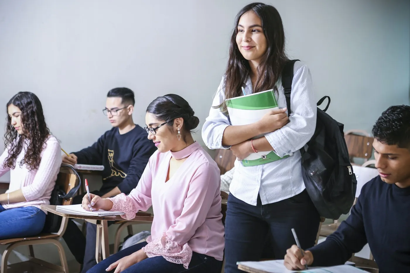 College student holding her textbooks in class
