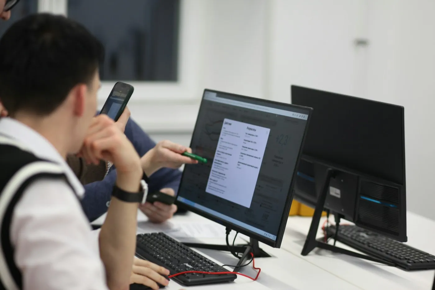 Students reviewing work on a computer in a lab